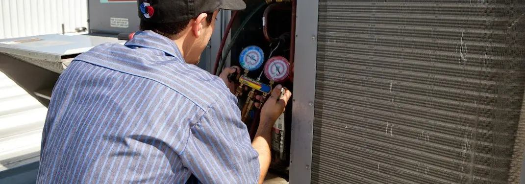 HVAC technician servicing a condenser unit in Mount Vernon